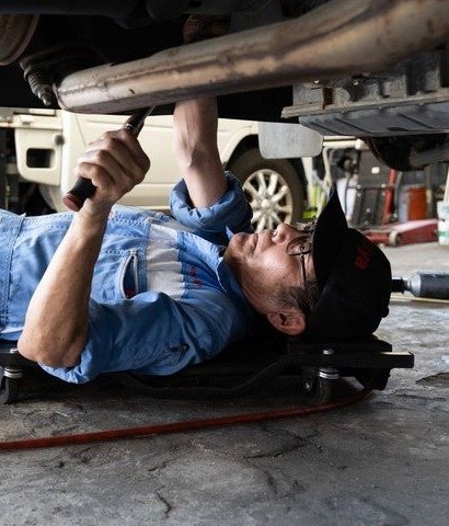 車の下に入って整備をする整備士